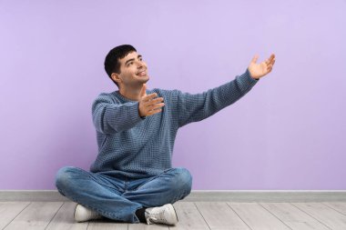 Genç adam sarılmak için kollarını açıyor leylak duvarın yanında