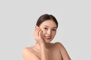 Gri arka planda güzel bir Asyalı kadın.