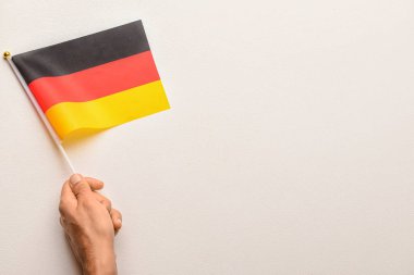 Beyaz arka planda Almanya bayrağı taşıyan bir erkek.