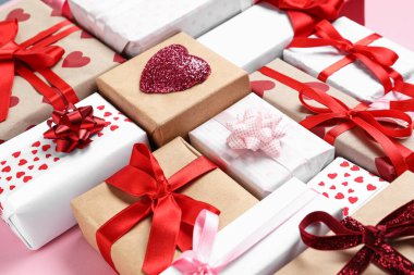 Pembe arka planda Sevgililer Günü kutlaması için farklı hediye kutularıyla kompozisyon, yakın plan.