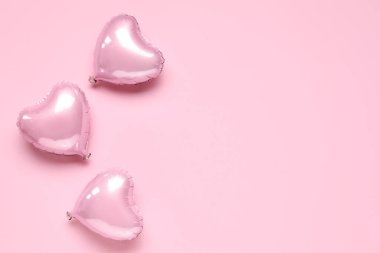 Pembe arka planda kalp şeklinde folyo balonları. Sevgililer Günü kutlaması