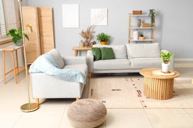 Kanepeleri ve bitkileri olan modern oturma odasının içinde.