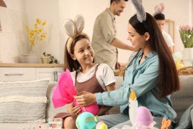 Mutlu küçük kız ve annesi Paskalya günü evde hediye yumurtasıyla