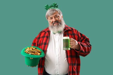 Yeşil arka planda bira içen olgun bir adam. Aziz Patrick Günü kutlaması