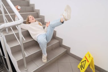 Genç bir kadın merdivenlerde ıslak basamaklara düştü. Travma konsepti