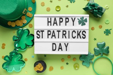 Sözcüklerle dolu tahta Mutlu Aziz Patrik Günü, yeşil arka planda leprikon şapka ve dekor