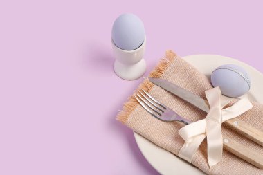 Eflatun arkaplanda Paskalya yumurtaları olan güzel bir masa.