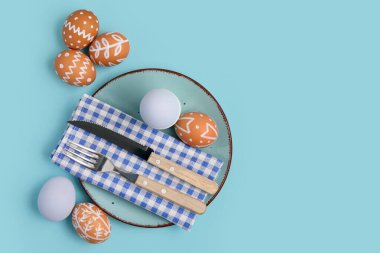 Mavi arka planda Paskalya yumurtaları olan güzel bir masa.