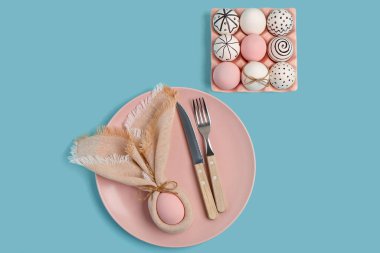 Güzel masa düzenleyicisi ve mavi arka planda Paskalya yumurtaları.