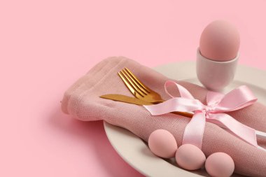 Pembe arka planda Paskalya yumurtaları olan güzel bir masa.