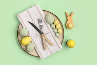 Yeşil arka planda Paskalya yumurtası ve tavşanı olan güzel bir masa.