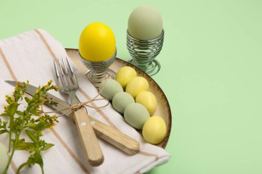 Paskalya yumurtaları ve yeşil arka planda sarı çiçeklerle güzel bir masa.