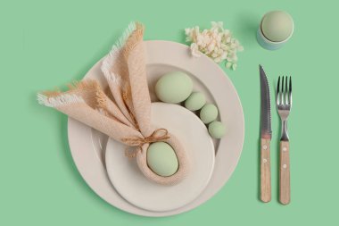 Yeşil arka planda Paskalya yumurtaları ve güzel çiçekleri olan masa ayarı