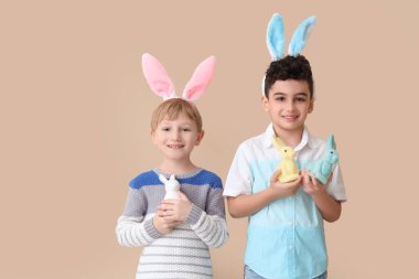Bej arka planda oyuncak tavşanı olan tavşan kulaklı şirin çocuklar. Paskalya kutlaması