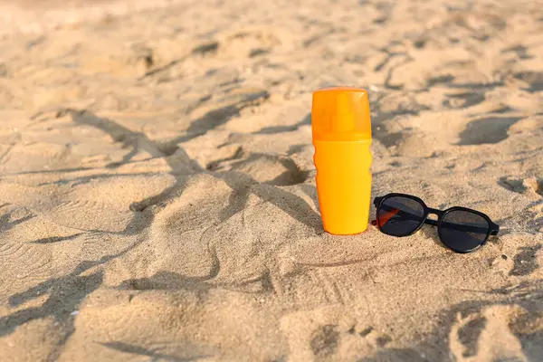 Stilvolle Schwarze Sonnenbrille Und Sonnencreme Auf Sand — Stockfoto