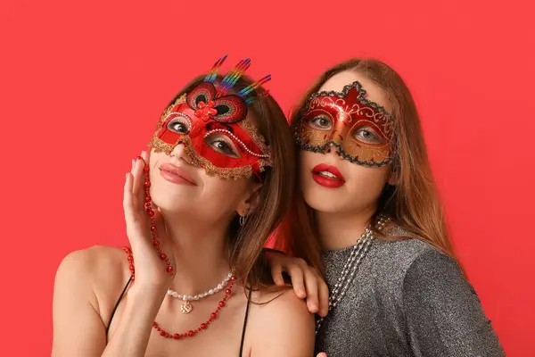 Bonitas Mujeres Jóvenes Máscaras Carnaval Sobre Fondo Rojo —  Fotos de Stock