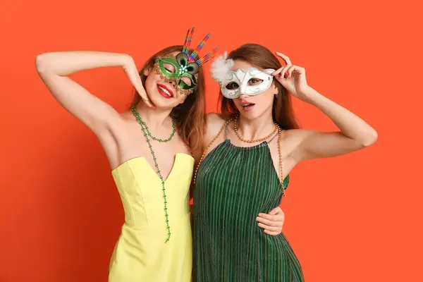 Hermosas Mujeres Jóvenes Máscaras Carnaval Sobre Fondo Naranja —  Fotos de Stock