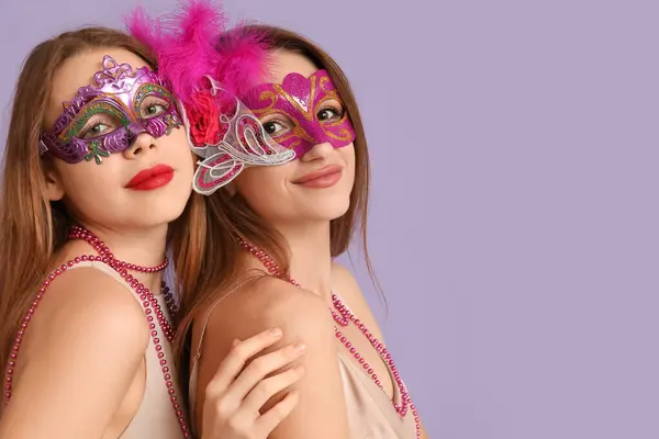 在紫丁香背景下戴狂欢节面具的年轻貌美女子 — 图库照片