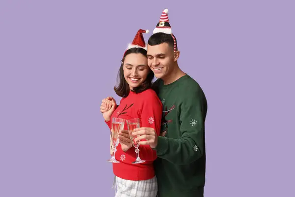 Glückliches Junges Paar Weihnachtlichen Pyjama Und Mit Champagner Auf Fliederfarbenem — Stockfoto