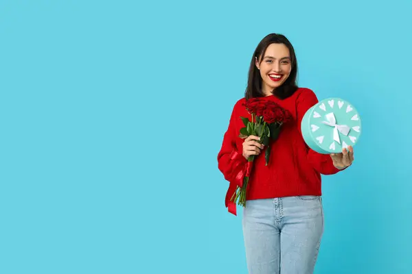 Красивая Молодая Счастливая Женщина Подарочной Коробкой Букетом Роз Синем Фоне — стоковое фото