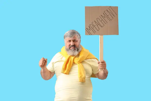 stock image Protesting mature man holding placard with word IMPEACHMENT on blue background