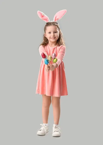 可爱的小女孩 戴着灰色背景的复活节彩蛋 长着小兔子耳朵 — 图库照片
