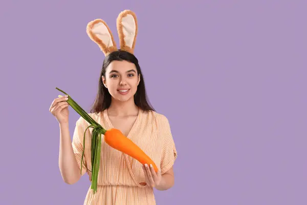 Beautiful Young Woman Bunny Ears Toy Carrot Lilac Background Easter — Stock Photo, Image