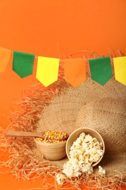 Hasır şapkalı mısır kaseleri ve kırmızı arka planda bayraklar. Festa Junina (Haziran Festivali) kutlaması