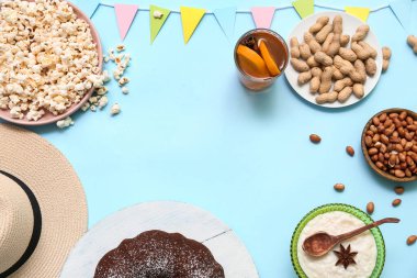Festa Junina (Haziran Festivali) için geleneksel yiyecek ve bayraktan yapılmış çerçeve mavi arka planda