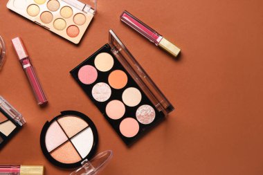 Güzel göz falı paletleri ve kahverengi arka planda farklı dekoratif kozmetikler.