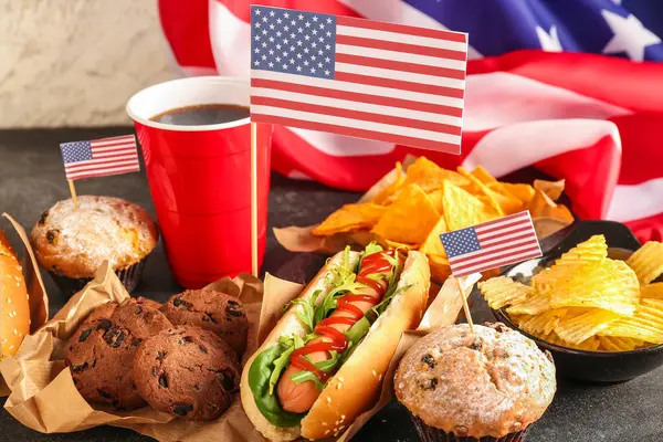 Tasty dishes, drink and American flag on dark table, closeup. Memorial Day celebration