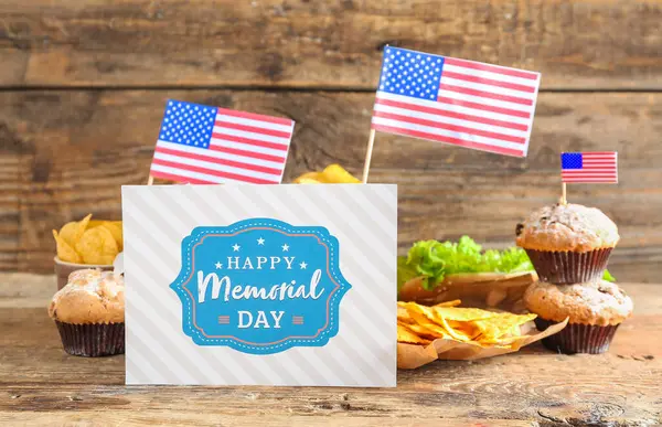 Card with text HAPPY MEMORIAL DAY and different dishes on wooden background