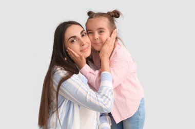 Küçük tatlı kızı beyaz arka planda mutlu bir anne.