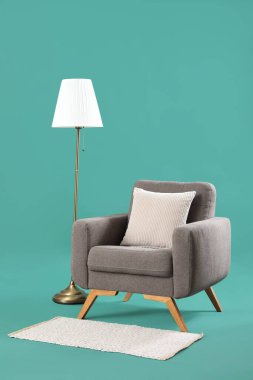 Turkuaz arka planda standart lambalı rahat koltuk