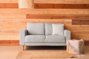 Gri kanepe, hasır sepet ve lambayla oturma odasının içinde.