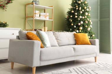 Rahat kanepesi ve Noel ağacı olan modern bir oturma odası.