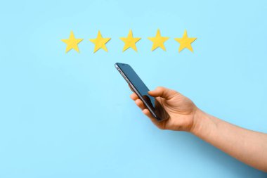 Beş yıldız ve mavi arka planda cep telefonu olan bir kadın. Müşteri deneyimi kavramı