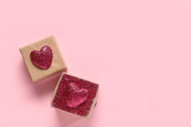 Pembe arka planda parlayan kalplerden yapılmış hediye kutuları. Sevgililer Günü kutlaması