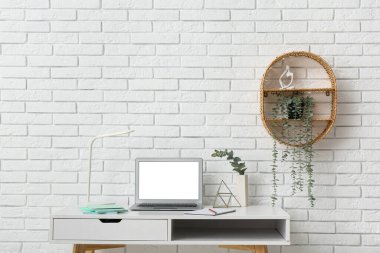 Dizüstü bilgisayarı ve ev bitkileri olan modern ofis işyeri.