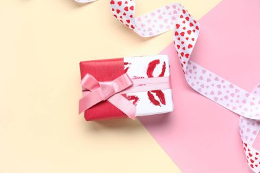 Renkli arka planda güzel bir hediye kutusu ve kurdele. Sevgililer Günü kutlaması