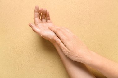 Kadın ellerini renk arkaplanına sürterek ellerini ovalıyor.