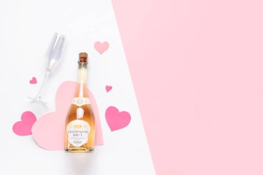 Bir şişe şampanya ve arka planda cam ve kağıt kalpler. Sevgililer Günü kutlaması