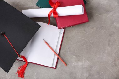 Diplomalı havan topu tahtası ve gri arkaplan üzerine not defterleri