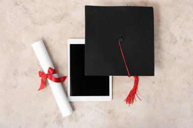 Diplomalı havan mermisi tahtası ve bej arka planda modern tablet bilgisayar