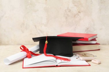 Havan mermisi, diploma, gözlük ve bej arkaplan üzerine not defterleri.