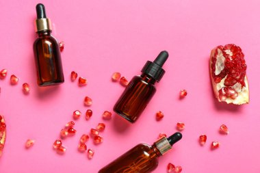 Gerekli yağ şişeleri ve arkaplanda taze nar kompozisyonu