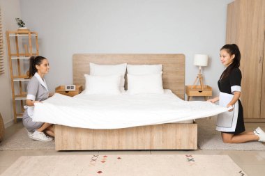 Genç oda hizmetçileri yatak odasında yatıyorlar.