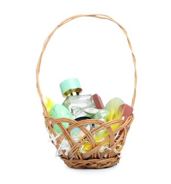 Dekoratif kozmetik ürünleri ve beyaz arka planda izole Paskalya yumurtaları olan hasır sepet.