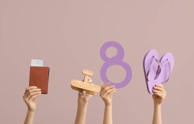 Kağıt sekizli kadın eller, parmak arası terlikler, tahta uçak ve renkli pasaport. Uluslararası Kadınlar Günü