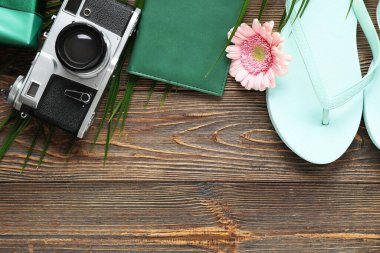 Fotoğraf makineli kompozisyon, pasaport ve tahta arka planda parmak arası terlik. Uluslararası Kadınlar Günü